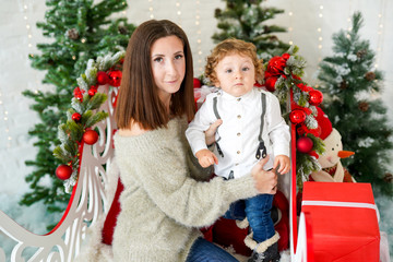 Portrait of happy family mother and her sun in decorated Christmas room