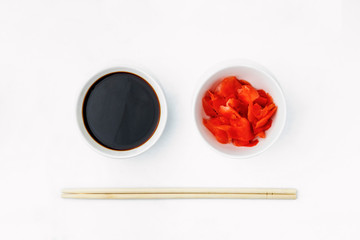 Funny face image of emoticon from soy sauce, pickled ginger and chopsticks, isolated on a white background. Creative oriental cuisine, restaurant concept. Copy space