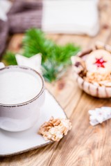 Fototapeta na wymiar Christmas mood. White cup of coffee cappuccino and homemade cookies. Blurred background