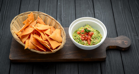 A delicious authentic mexican guacamole dip with avocado, lime, and tomato.