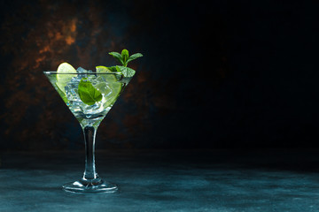 Mojito cocktail in martini glass on black background