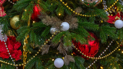 Christmas and New Year composition. Christmas tree branch decorated with Xmas lights,  balls, cones, snowflakes, baubles. Holiday background.