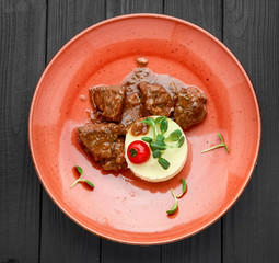 rich and savory beef bourguignon with mashed potatoes on a plate on wooden surface