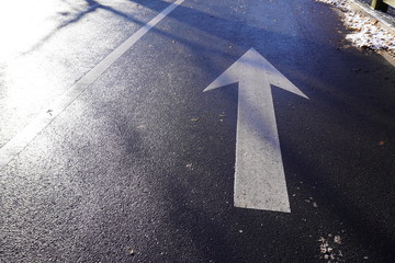 pointing up white arrow on the wet ground