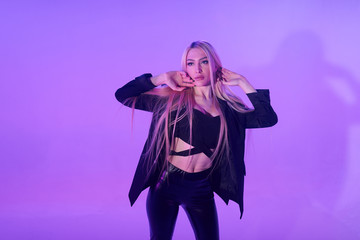 Attractive blonde woman sitting on the chair over pink background