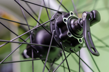 Bicycle repair workshop. On the hook hang new wheels. The rim, spokes and hub black colour. The old...