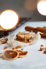 Christmas composition. cookies tied, rolling pin, cinnamon, cookies and dried orange, nuts, raisins. 