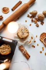 Fototapeta na wymiar Christmas composition. cookies tied, rolling pin, cinnamon, cookies and dried orange, nuts, raisins. The view from the top