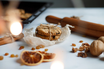 Christmas composition. cookies tied, rolling pin, cinnamon, cookies and dried orange, nuts, raisins. 
