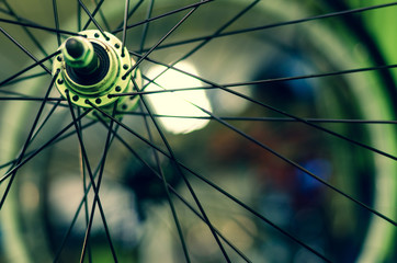 Bicycle repair workshop. On the hook hang new wheels. The hub is black and the spokes and rim are...