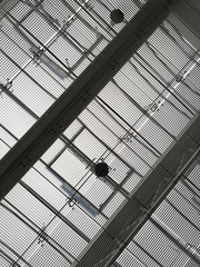 Ceiling of industrial or office building with metal girders and grid structures. Abstract black and white background on the subject of modern architecture, industry or business.