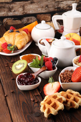 Breakfast served with coffee, orange juice, croissants, cereals and fruits. Balanced diet. Continental breakfast with granola and fruits