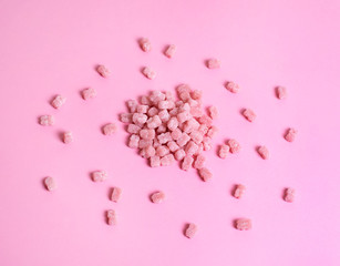 Pink vitamins in the shape of a bear on a pink background. It's like sweet marmalade in sugar.
