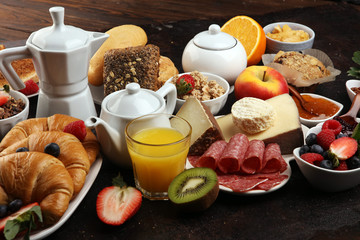 Breakfast served with coffee, orange juice, croissants, cereals and fruits. Balanced diet. Continental breakfast with granola and fruits