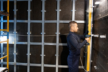 Make soundproofing in room. Carpenter measure the level of wall. Horizontal. Renovation at home. Building construction indoor. .