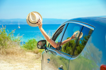 happy girl from car at sea greece background