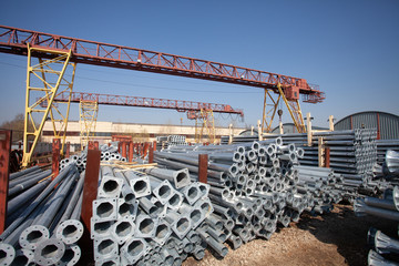 Naklejka premium Metal warehouse outdoor of lighting poles. Storage of metal galvanized faceted pipes with flange.