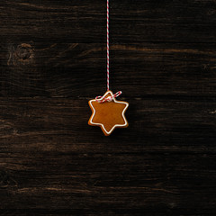 Christmas gingerbread cookies hanging over wooden background