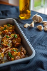 Freshly baked potatoes in a oven tray with fresh garlic and olive oil