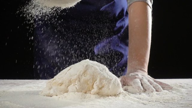 woman's hands sifts flour through a sieve on the dough, slow mot
