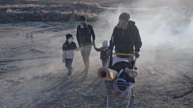 Survivor family in gas mask walking through clouds of toxic smoke and burning in a desert landscape.
