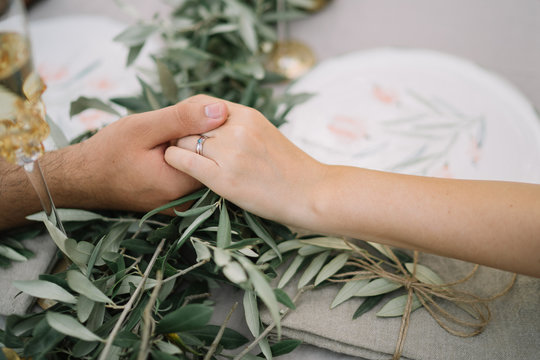 In love couple, maried, holding hands over the table