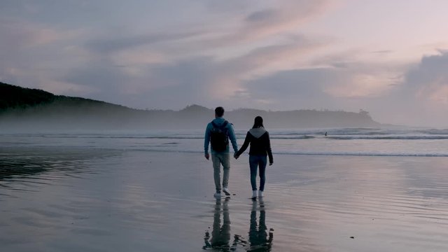 Tofino Vancouver Island, aerial view at the beach of Tofino with people surfing during sunset Vancouver Island Canada, couple walking on the beach