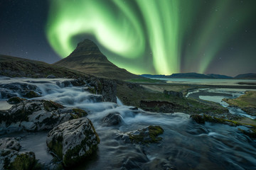 Northern lights/Aurora borealis over the famous mountain Kirkjufell and kirkjufellsfoss waterfall...