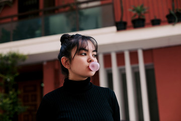 Asian girl blowing a bubble gum