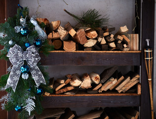 christmas decorations with fir branches, cinnamon, balls and toys on a firewood, outdoor
