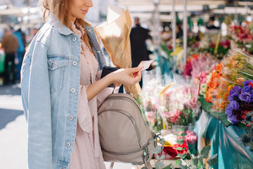 Unrecognizable woman buying flowers at market