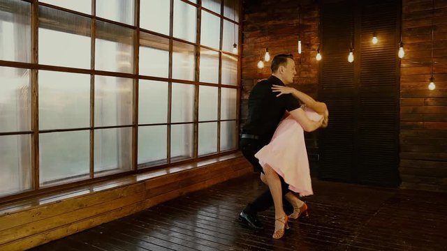 Dirty dancing, dancing couple in love on Valentine's Day, on a brown background, at dusk, shooting in the studio, romantic party in vintage style