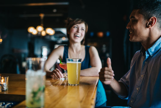 Friends talking and laughing during happy hour
