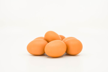 Close up of a clutch of fresh eggs on a plain white background with space for copy