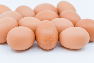 Close up of a clutch of fresh eggs on a plain white background with space for copy