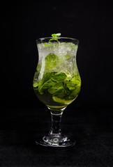 Mojito with lime, mint and ice. a beautiful cocktail on an isolated, black background.