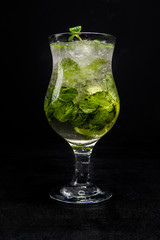 Mojito with lime, mint and ice. a beautiful cocktail on an isolated, black background.