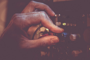 Man's hand adjusting the volume in a music synthesizer. Retro style.