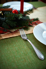 Christmas mood. New Year's table decorations, white plate on green background