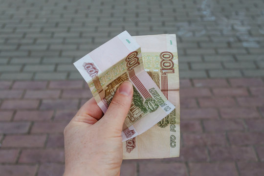 female hand holding new russian banknotes against window. two hundred roubles. Cash paper money.