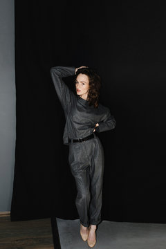 Trendy model posing against black fabric