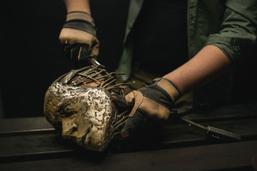 Crop man holding ornamental metal skull