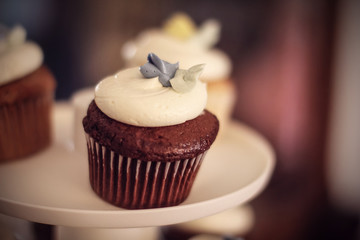 Chocolate cupcake with white frosting on a cupcake stand