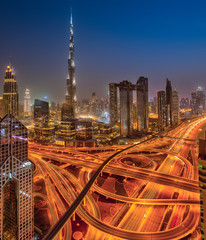 Dubai skyline during sunrise with shining traffic road, United Arab Emirates.