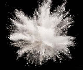 White powder explosion on black background. Freeze motion.