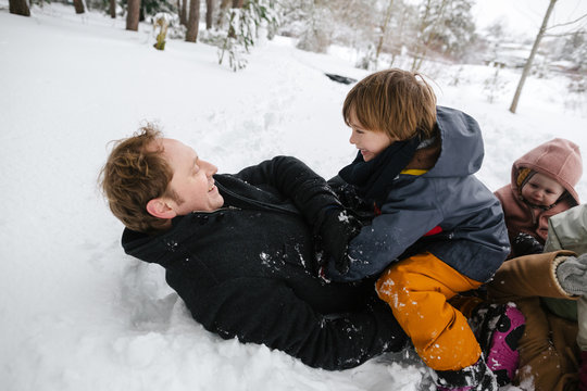 Young family having fun playing togther in the snow.