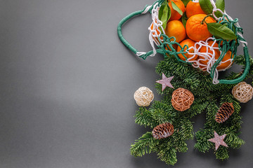 Top view tangerines in a mesh shopping bag and Christmas tree branches. Zero Waste and NO plastic bag Concept. Copy space