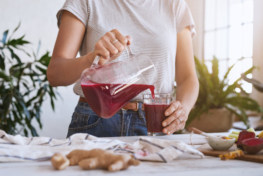 Woman making beetroot juice in kitchen