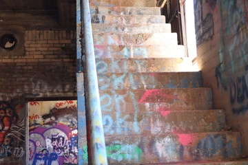 Graffiti on cement stairs that climb to the second floor of an abandoned warehouse