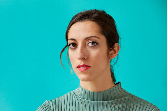 Portrait of a young woman sitting on a turquoise background - Powered by Adobe